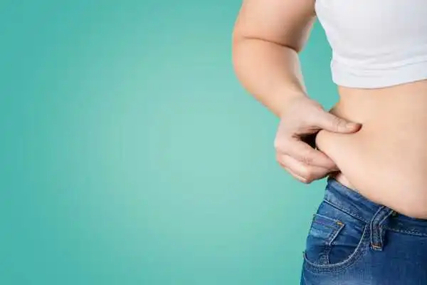 Image of woman pinching her love handles to show weight gain Stoke on Trent